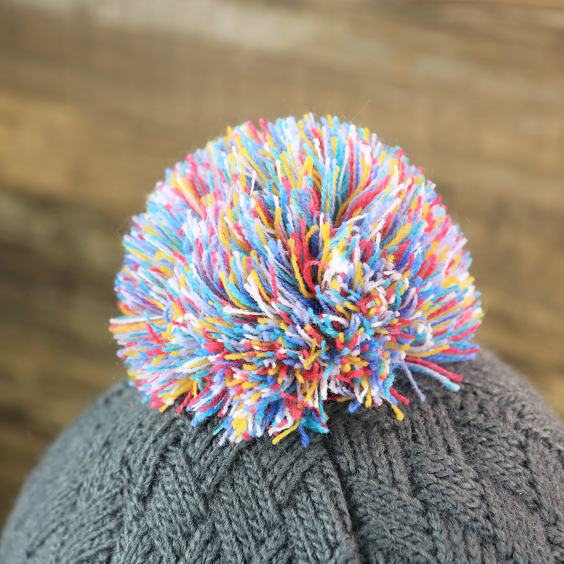 The Rainbow Pom Pom on the Women's Philadelphia Eagles On Field NFL Crucial Catch Intercept Cancer Patch Rainbow Pom Pom Winter Beanie | Graphite Gray Winter Beanie