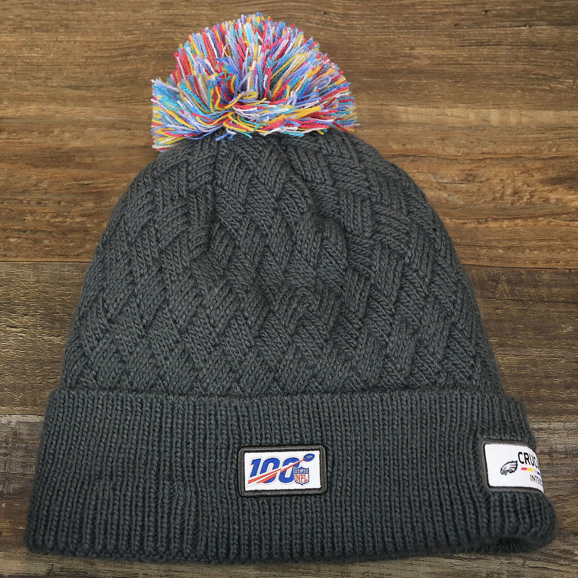 The backside of the Women's Philadelphia Eagles On Field NFL Crucial Catch Intercept Cancer Patch Rainbow Pom Pom Winter Beanie | Graphite Gray Winter Beanie