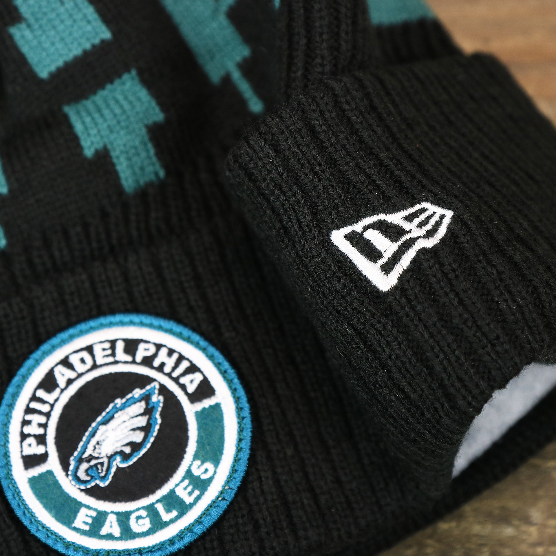 The New Era Logo on the Philadelphia Eagles Sideline On Field Pom Pom Winter Beanie | Black Winter Beanie
