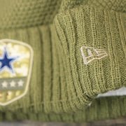 The New Era Logo on the Women’s Dallas Cowboys Salute To Service Ribbon Rubber Military Cowboys Patch On Field NFL Beanie | Women’s Military Green Beanie