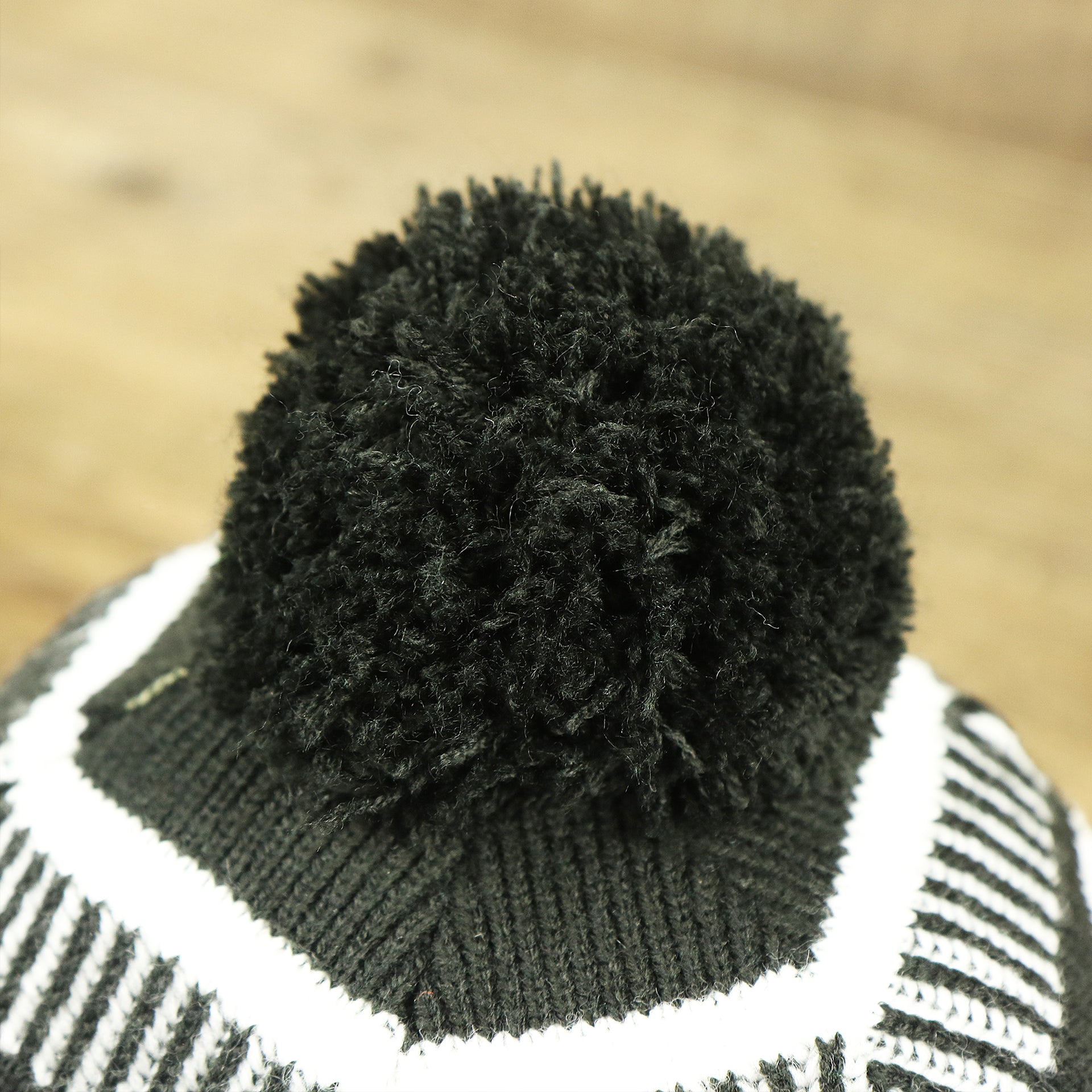 The black pom pom on the Philadelphia Eagles On Field Cuffed Winter Pom Pom Beanie | Black And White Winter Beanie