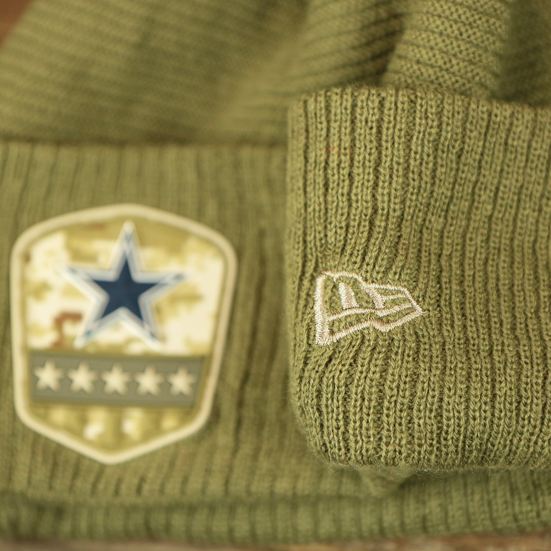 The New Era Logo on the Dallas Cowboys Salute To Service Ribbon Rubber Military Cowboys Patch On Field NFL Beanie | Military Green Beanie