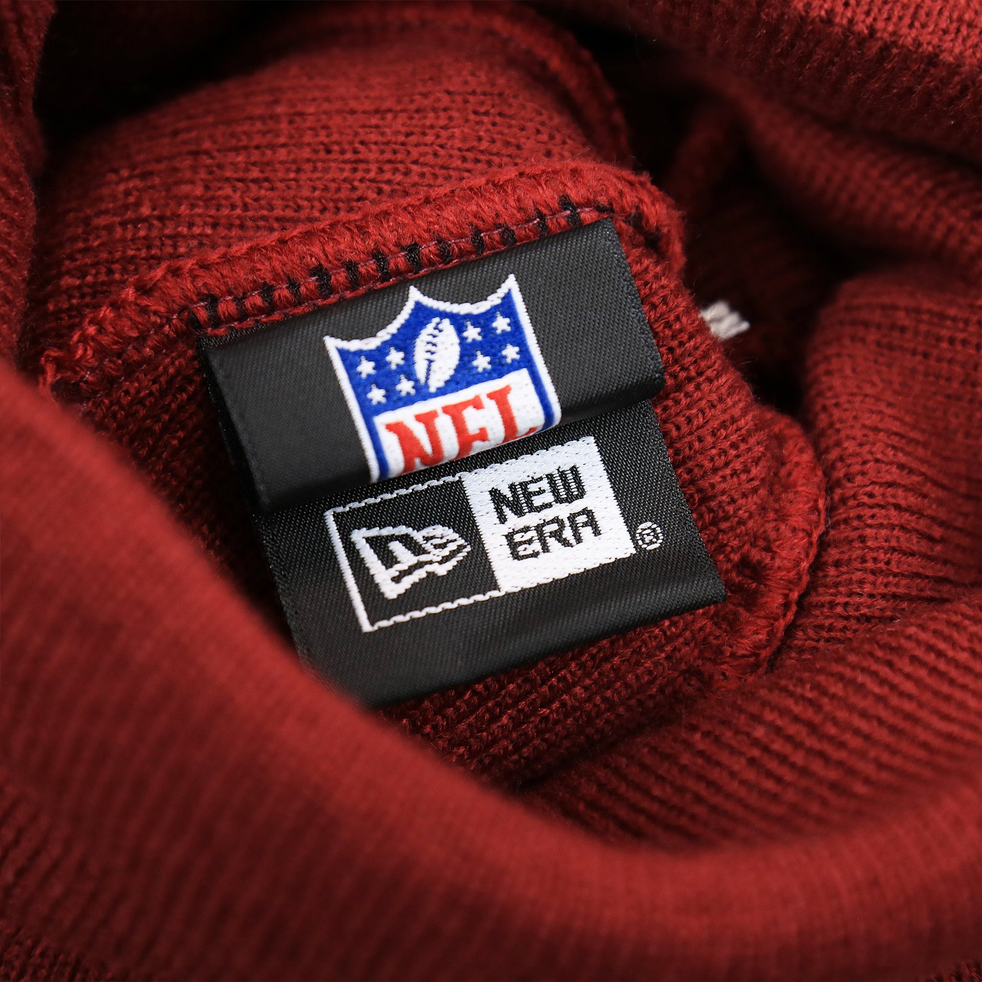 The New Era Tag on the Throwback Philadelphia Eagles White Logo Striped Cuffed Winter Beanie | Maroon Winter Beanie