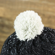 The White Pom Pom on the Women’s Las Vegas Raiders Reflective Silver Cuffed Pom Pom Winter Beanie | Black Winter Beanie