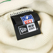 The New Era Tag on the Philadelphia Eagles Script Cuffed Winter Beanie With Pom Pom | Ivory Winter Beanie