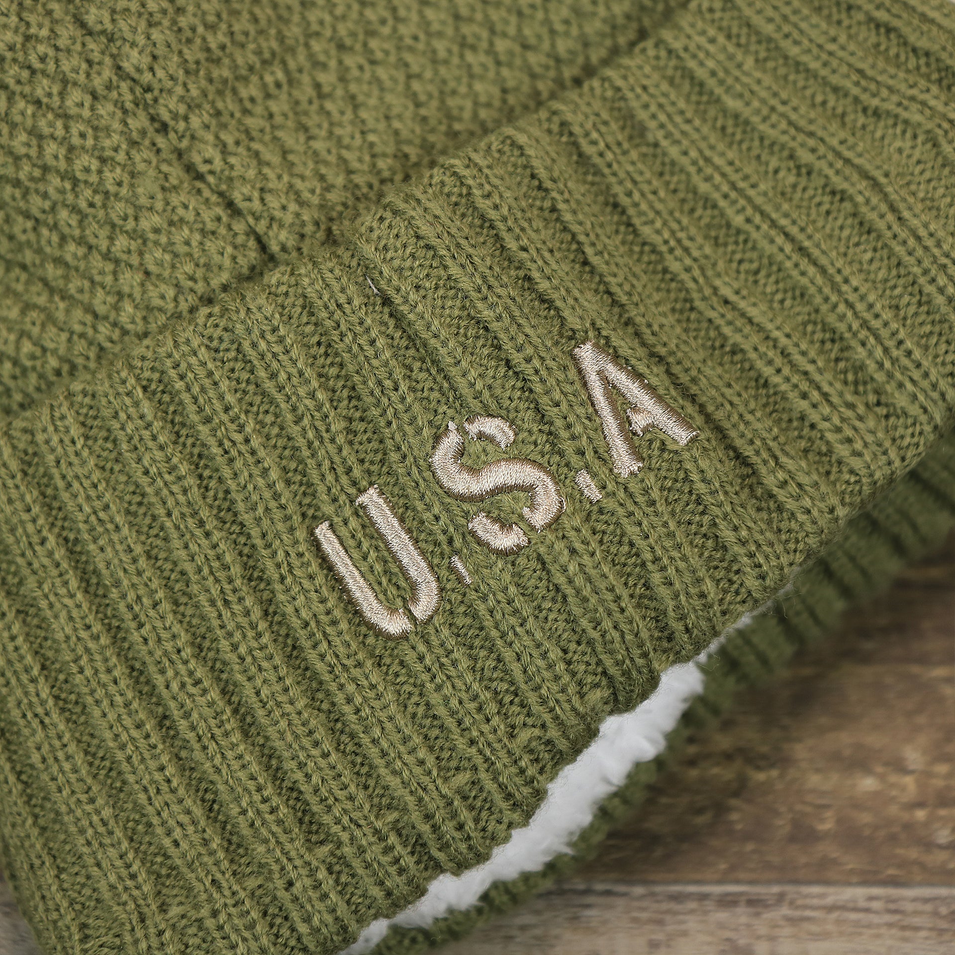 The USA Wordmark on the Women’s Philadelphia Eagles Salute To Service Ribbon Rubber Military Eagles Patch On Field NFL Beanie | Women’s Military Green Beanie