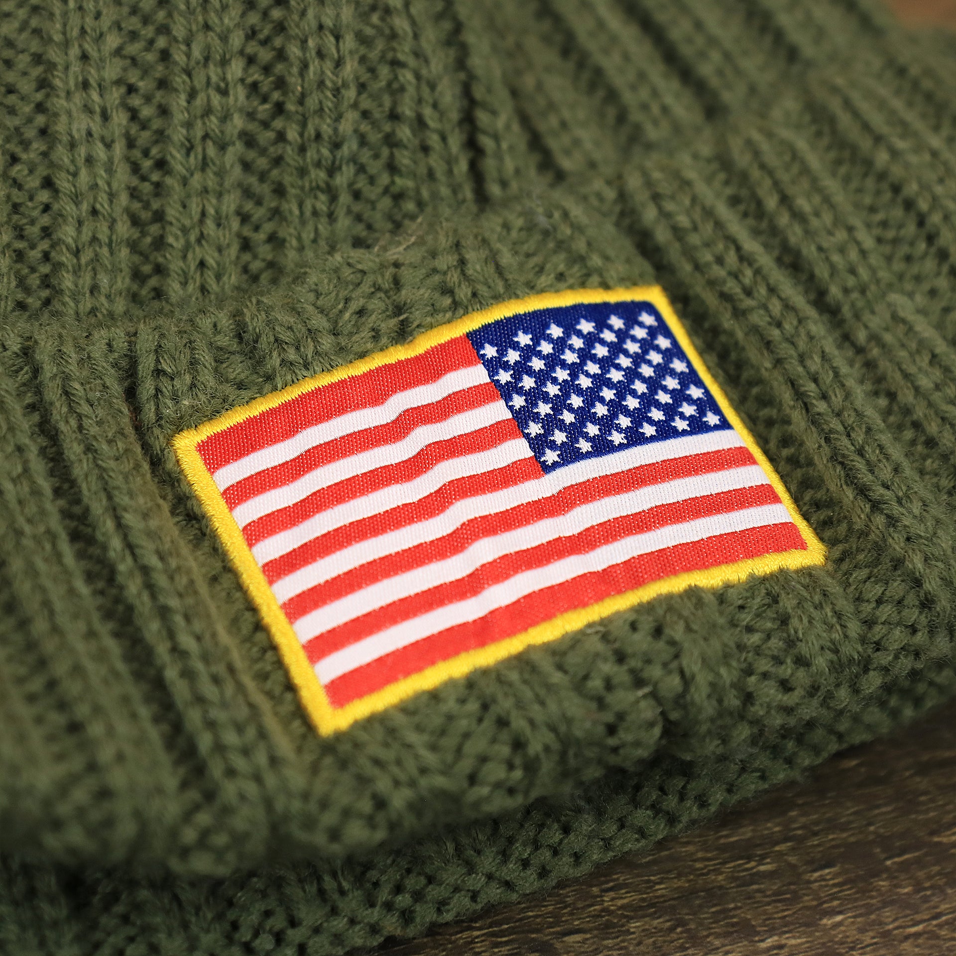 The USA Flag Patch on the Youth Dallas Cowboys on Field Salute To Service Ribbon American Flag Side Patch Winter Beanie | Kid’s Olive Green Winter Beanie