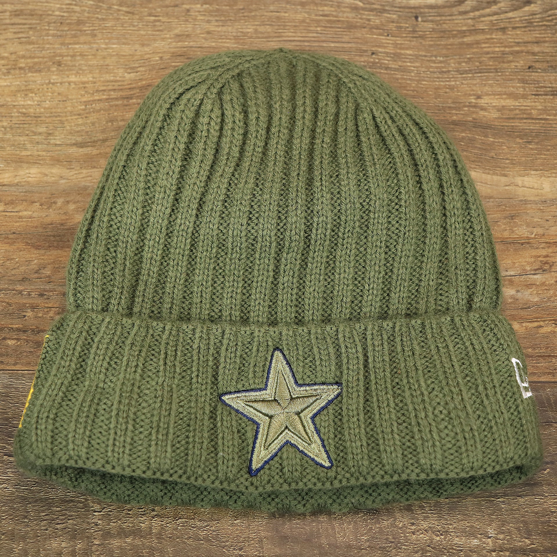 The front of the Youth Dallas Cowboys on Field Salute To Service Ribbon American Flag Side Patch Winter Beanie | Kid’s Olive Green Winter Beanie