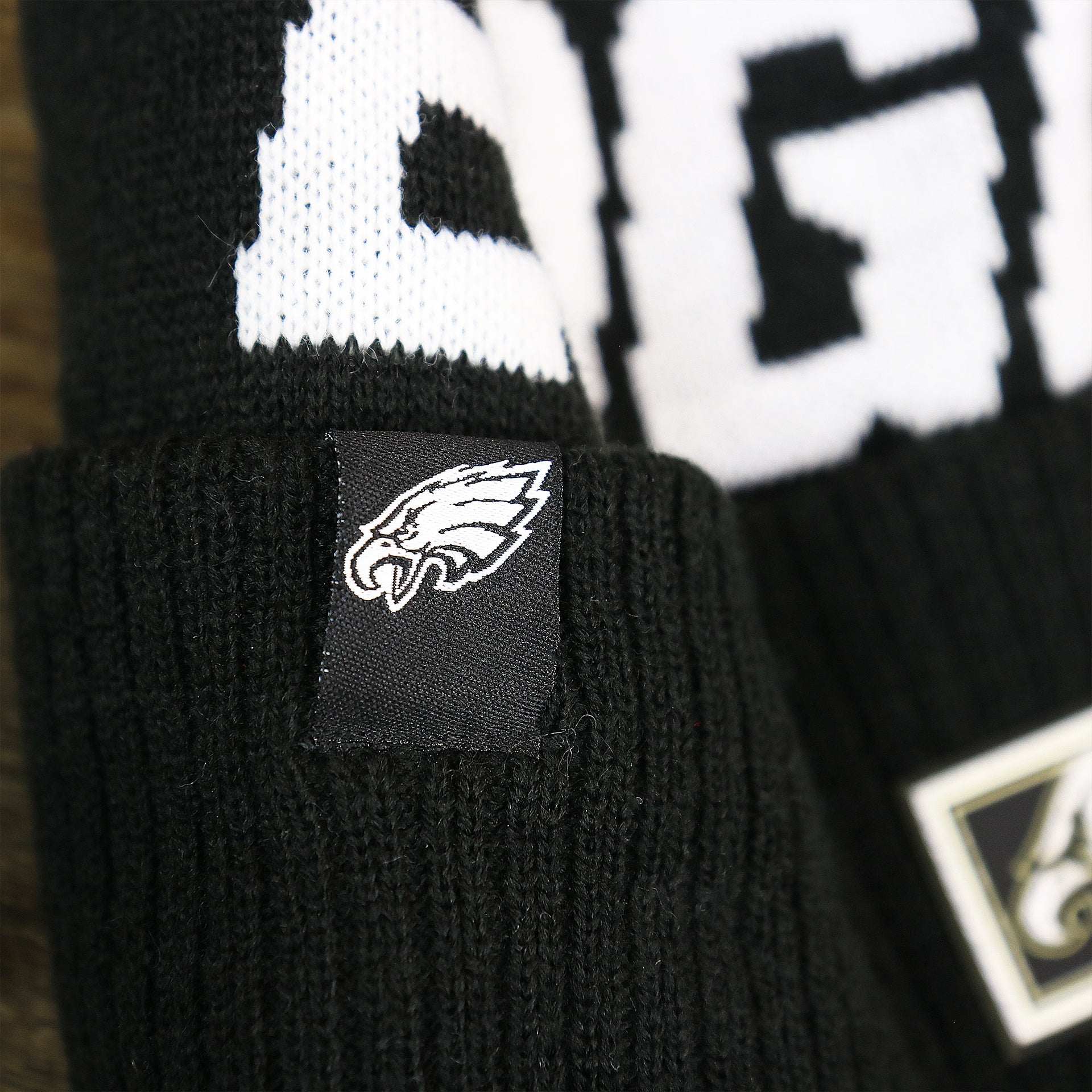 The Eagles Tag on the Philadelphia Eagles On Field Cuffed Winter Pom Pom Beanie | Black And White Winter Beanie