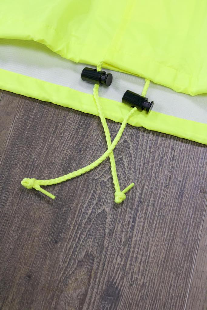 the bottom of the Police Public Safety | Waterproof Safety Green Windbreaker | Waterproof Neon Yellow Flannel Lined Coach Jacket  has adjustable strings