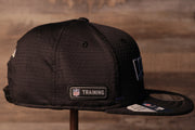 The wearers right side has the NFL Training Camp logo Ravens 2020 Training Camp Snapback Hat | Baltimore 2020 On-Field Black Training Camp Snap Cap