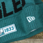The New Era Logo on the Philadelphia Eagles On Field Since 1933 Eagles Patch Winter Pom Pom Beanie | Midnight Green Winter Beanie