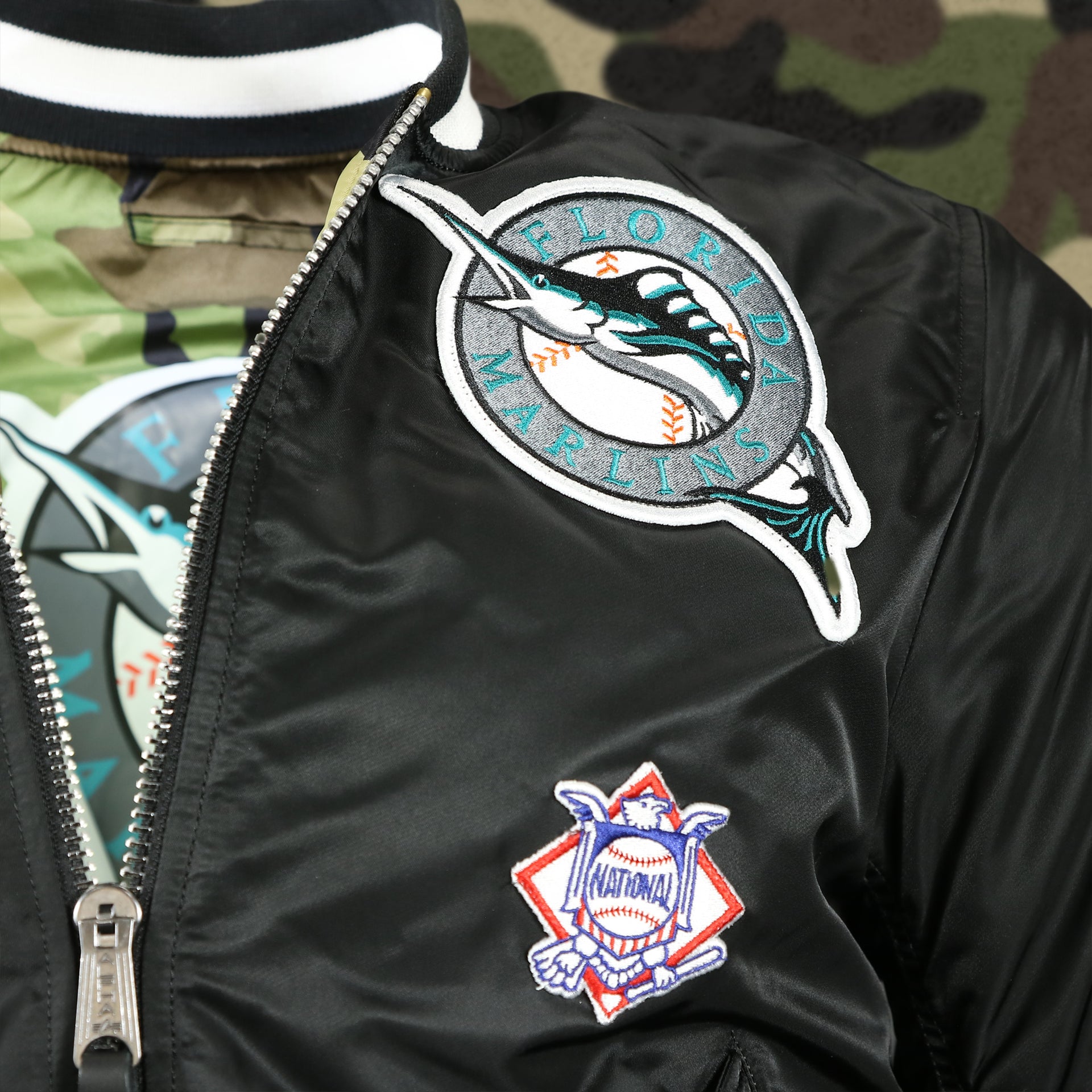 throwback marlins logo and national league patch on the Florida Marlins MLB Patch Alpha Industries Reversible Bomber Jacket With Camo Liner | Black Bomber Jacket