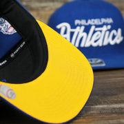 The Yellow Undervisor on the Cooperstown Philadelphia Athletics Wordmark Retro Athletics Side Patch Snapback | Royal Blue Snapback