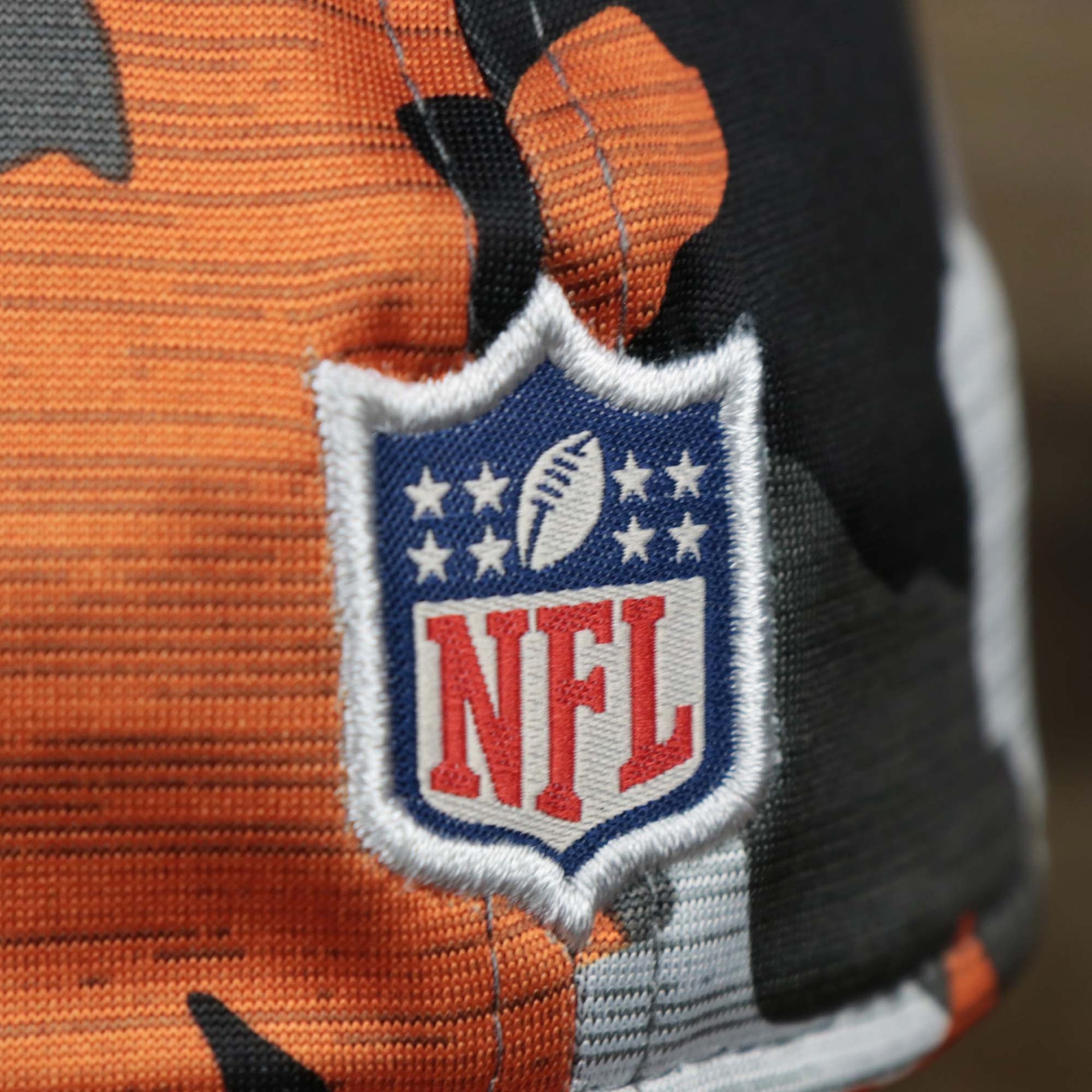 The NFL Logo on the Throwback Tampa Bay Buccaneers OnField NFL Summer Training 2022 39Thirty Camo FlexFit Cap | New Era Orange