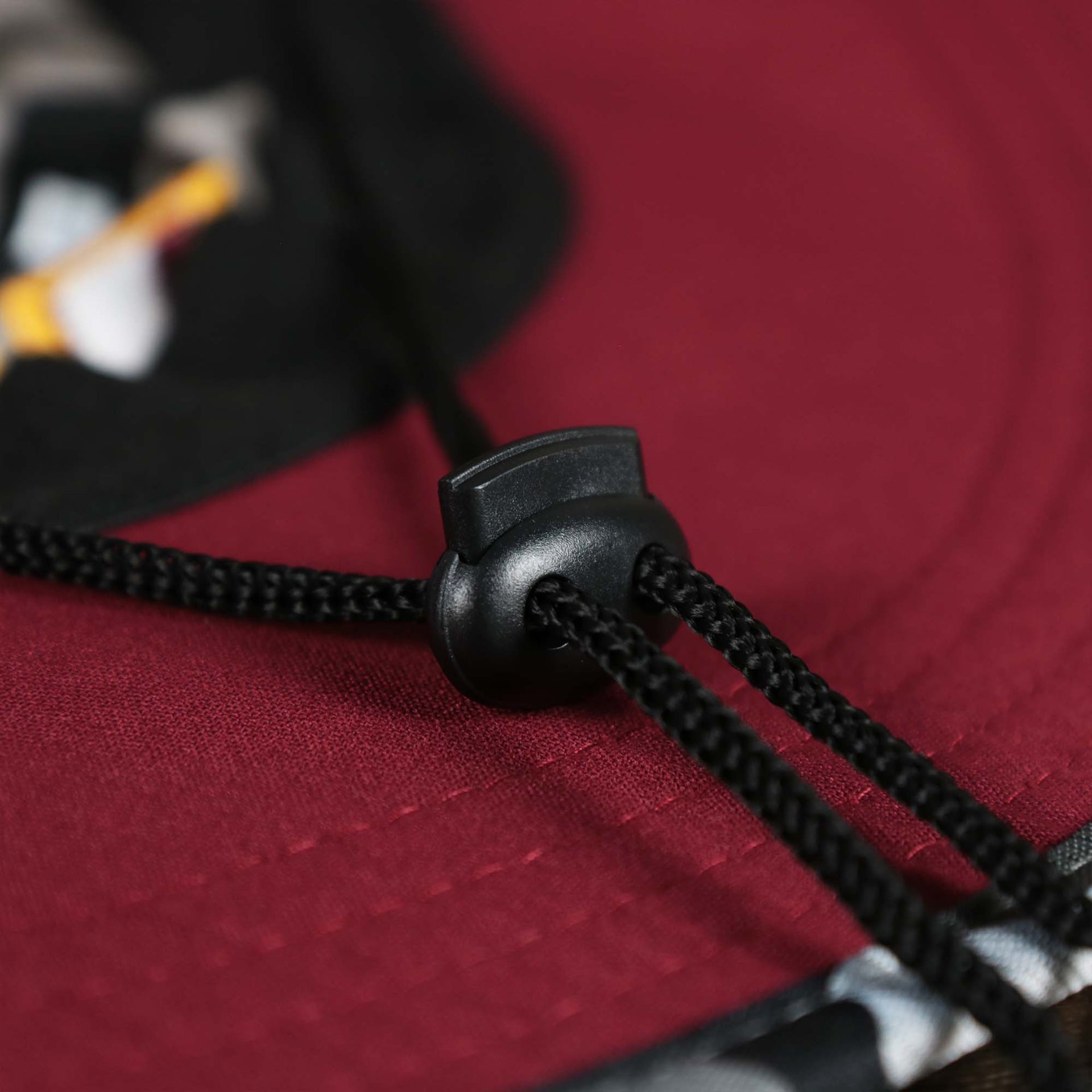 The Adjustable Chin Strap on the Washington Commanders NFL Summer Training Camp 2022 Camo Bucket Hat | Burgundy Bucket Hat