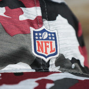 The NFl Logo on the Washington Commanders NFL Summer Training Camp 2022 Camo Bucket Hat | Burgundy Bucket Hat
