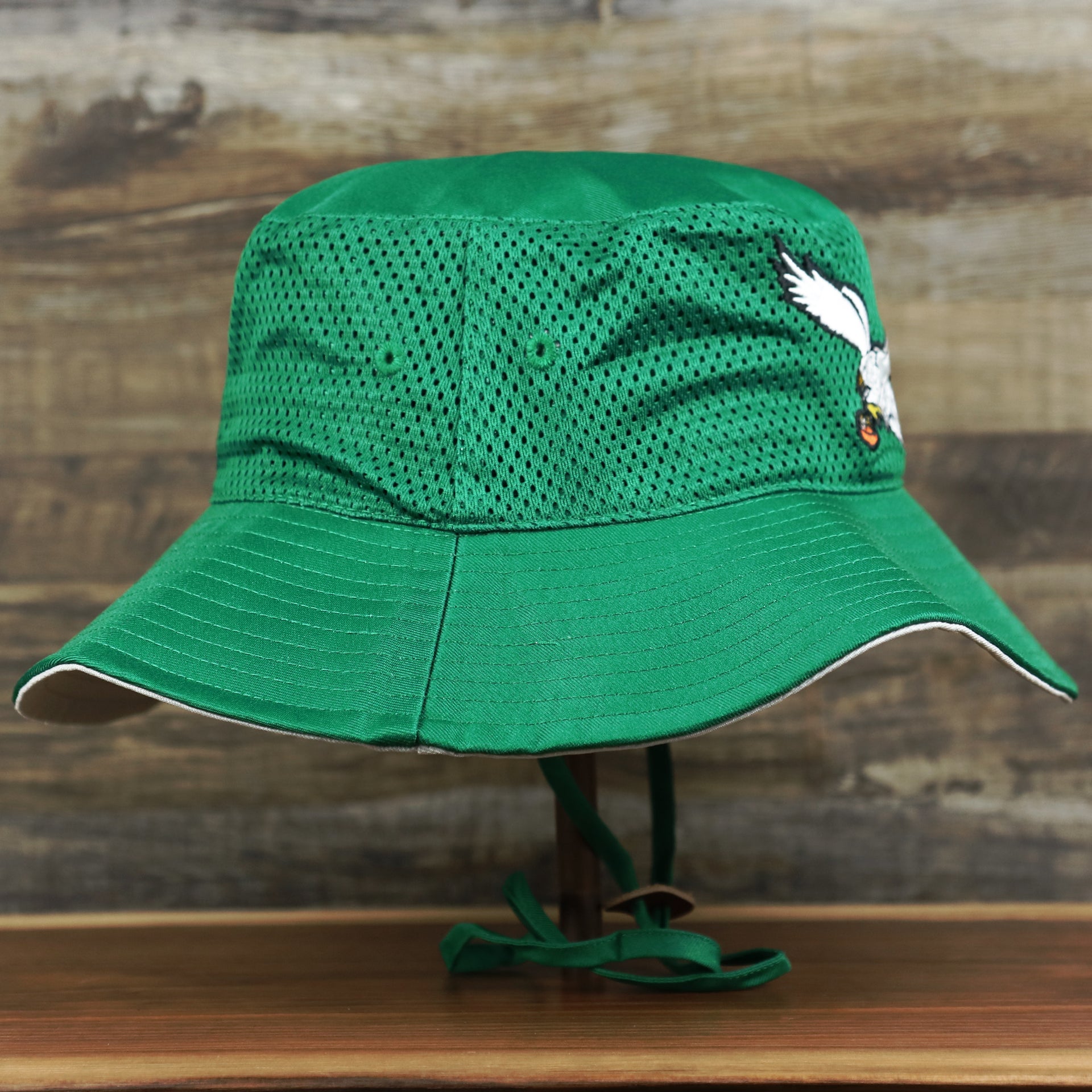 The wearer's right on the Throwback Philadelphia Eagles 1987 White Eagles Logo Panama Pail Bucket Hat | Kelly Green Bucket Hat