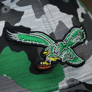 The eagles logo on the Throwback Philadelphia Eagles OnField NFL Summer Training 2022 39Thirty Camo FlexFit Cap | New Era Kelly Green