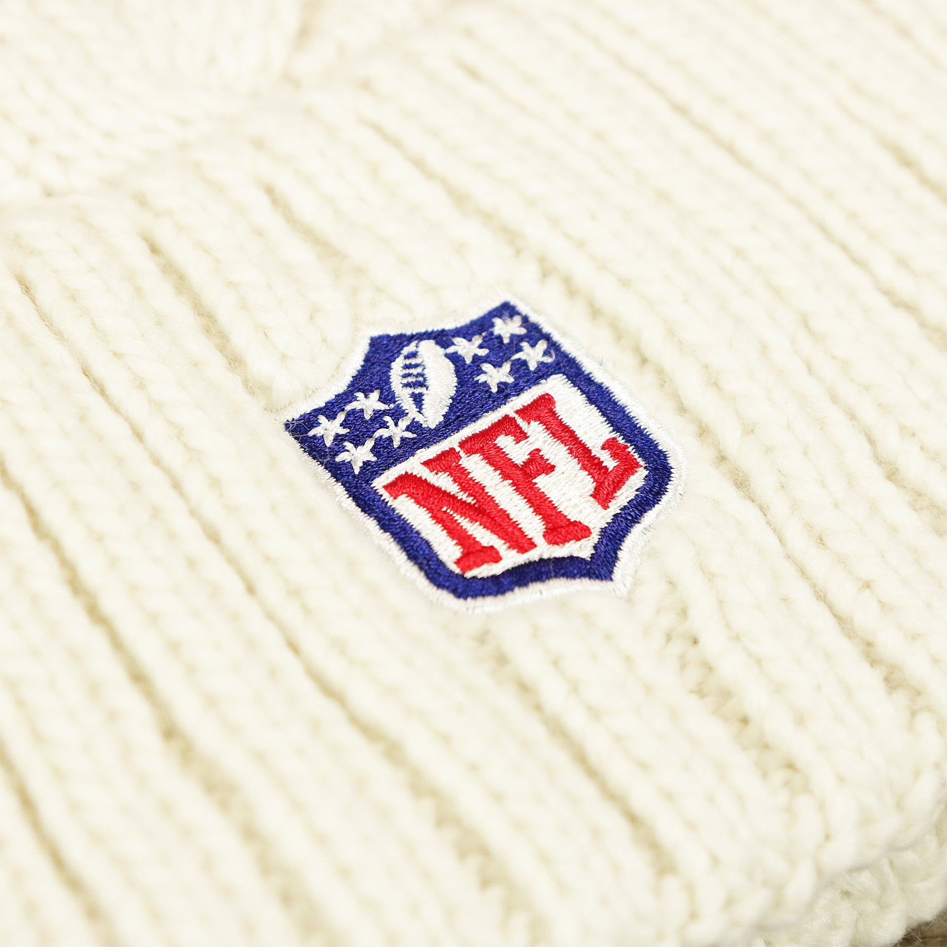 The NFL Logo on the Women’s New York Giants 2022 NFC Cuffed Winter Knit Meeko Pom Pom Beanie | Women’s White Winter Beanies