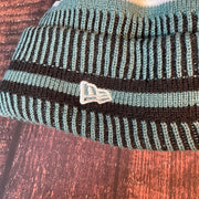Close up on the Philadelphia Eagles On Field Eagles Colorway Striped Pom Pom Beanie New Era Logo is white