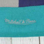 mitchell and ness logo on the Charlotte Hornets Cuffed Logo Split Beanie With Black Pom Pom | Teal, White, And Black Beanie
