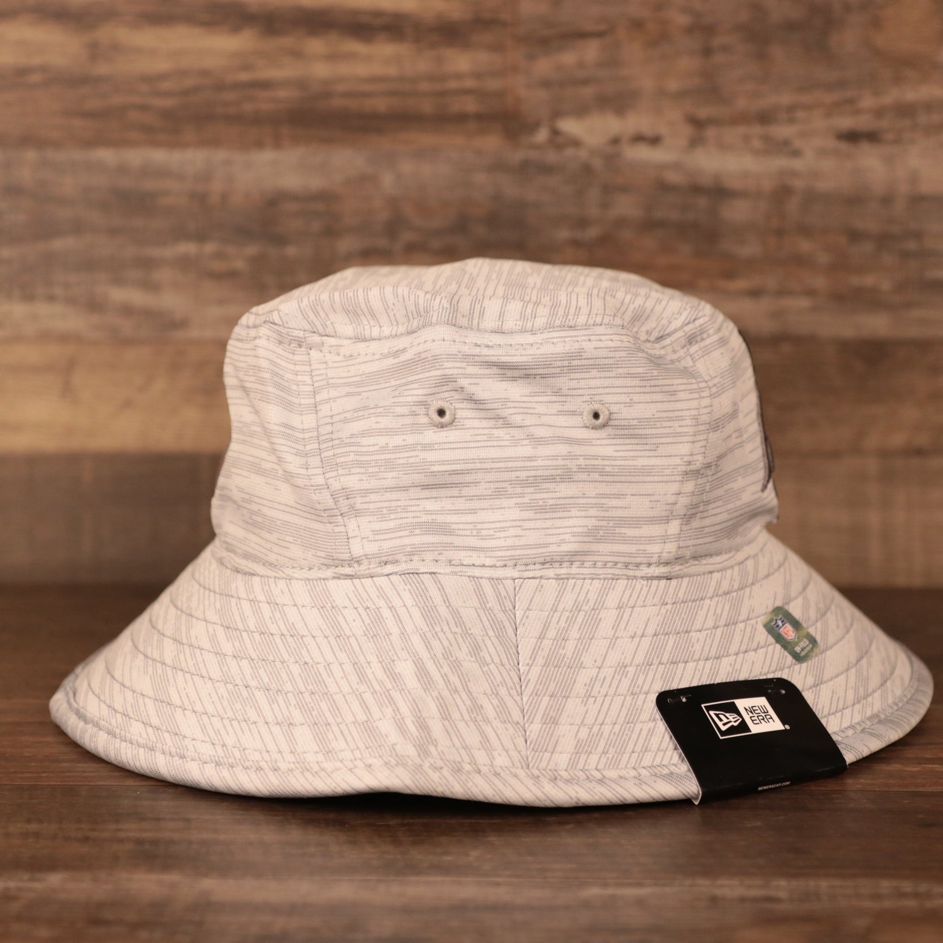 The ventilation holes on the side of the gray 2021 new era training carolina panthers bucket hat.