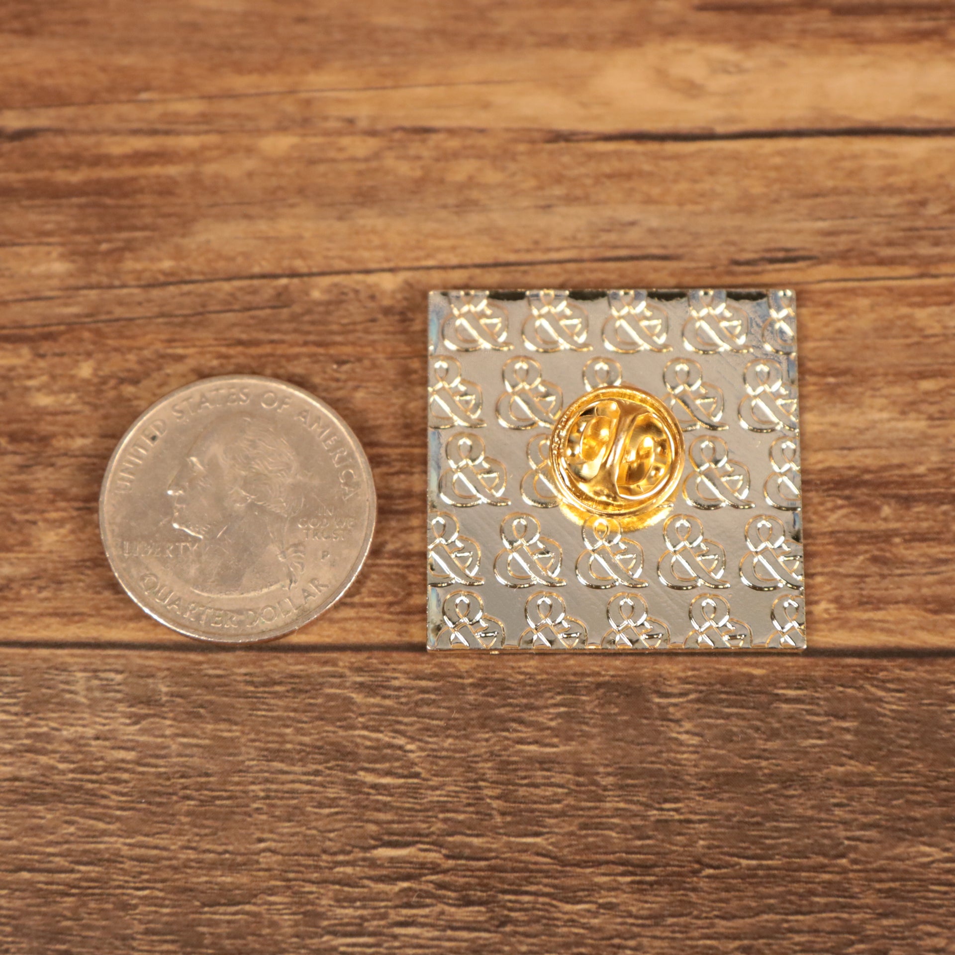 The backside of the Kufic Arabic Square Art Ahya Fitted Cap Pin | Enamel Pin For Hat compared to a quarter