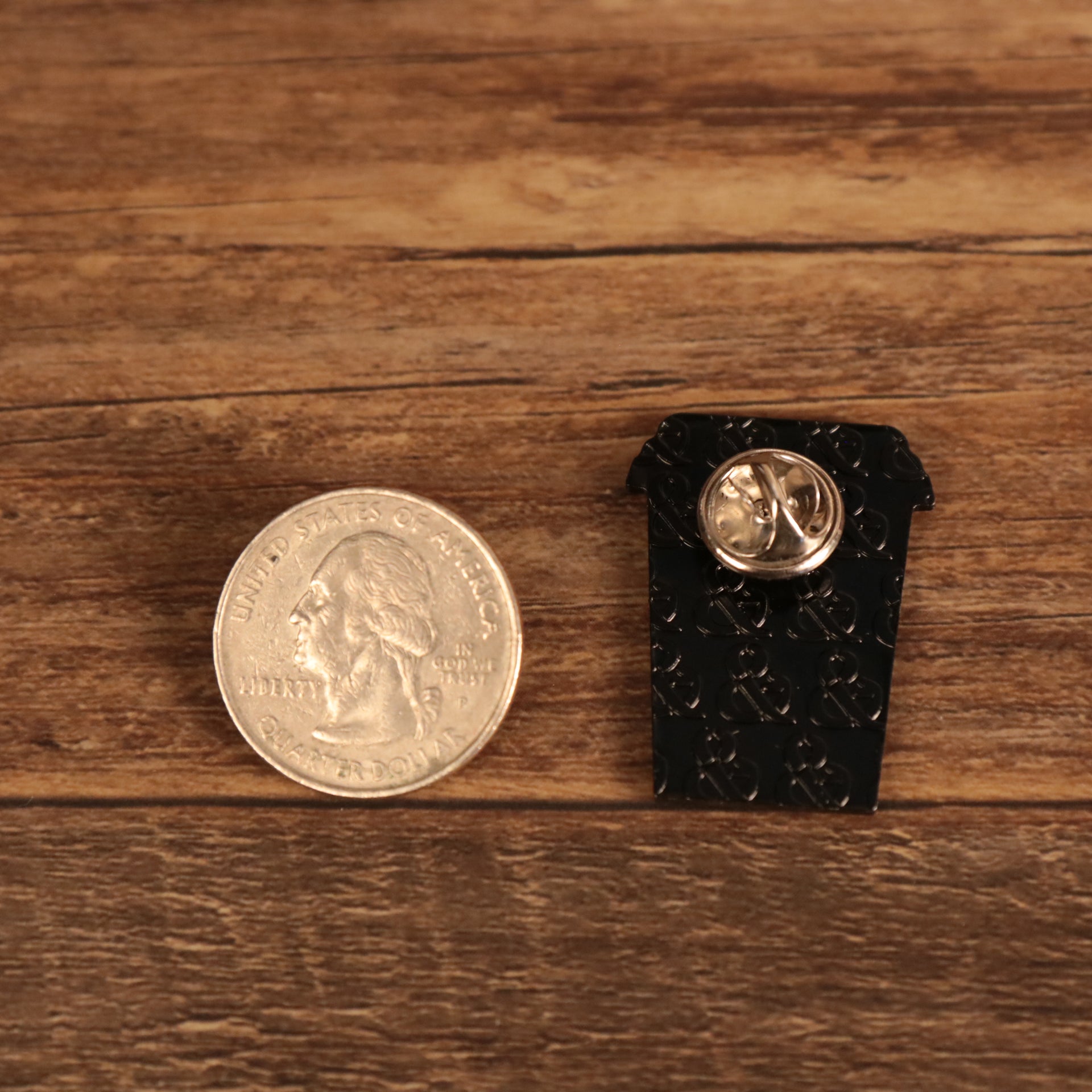 The backside of the New York Coffee Cup We Are Happy To Serve Fitted Cap Pin | Enamel Pin For Hat compared to a quarter