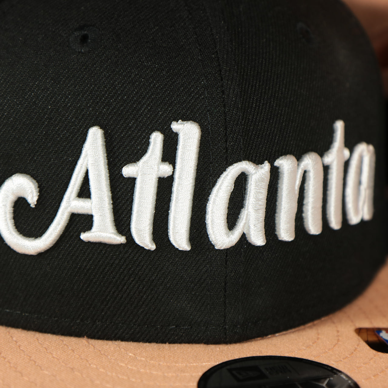 atlanta logo on the front of the Atlanta Hawks 2022 City Edition Atlanta Peach Logo Peach Bottom Youth 9Fifty Side Patch Snapback Cap | New Era, Black