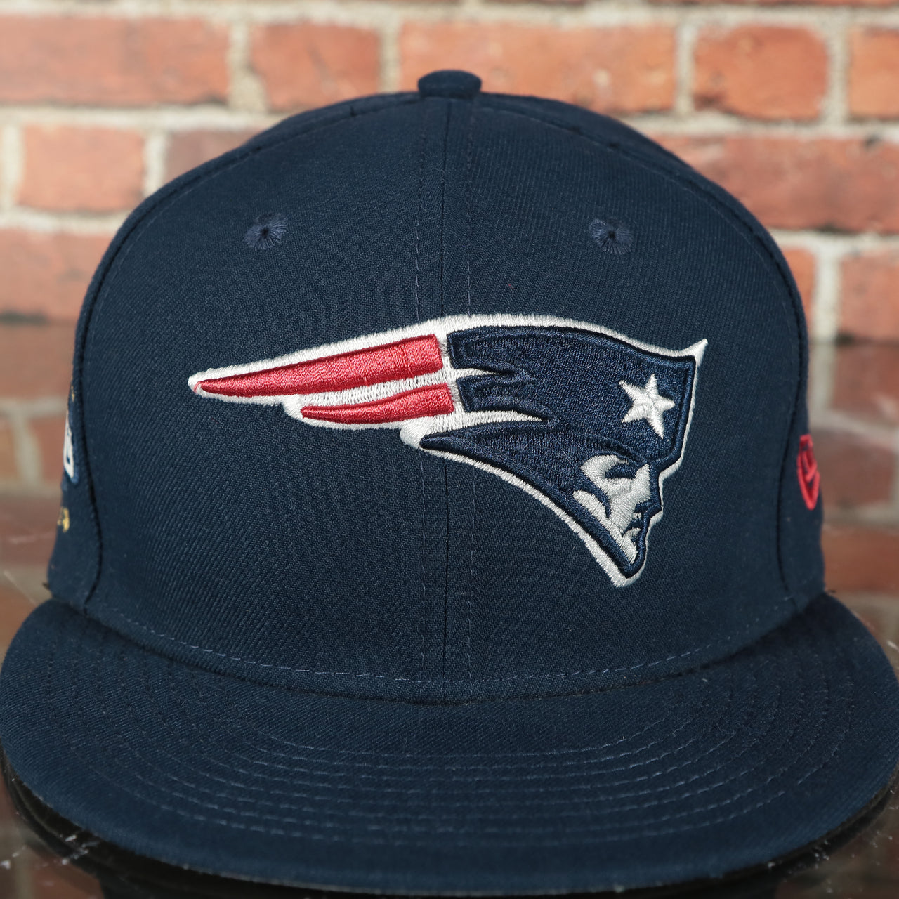 patriots logo on the New England Patriots Tribute Turn Grey Bottom | Navy 59Fifty Fitted Cap