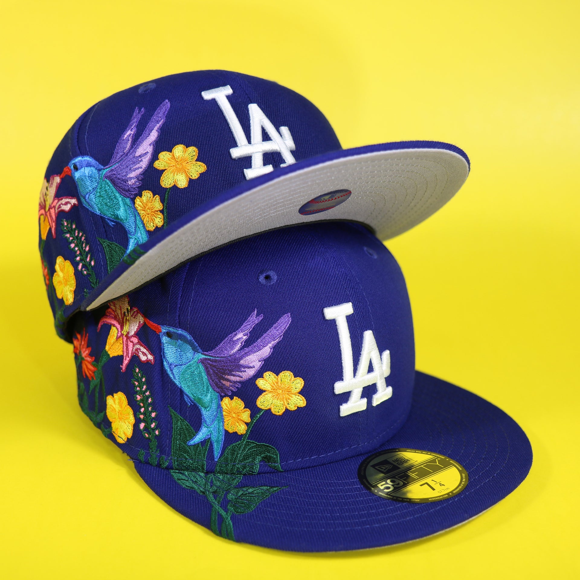 The Los Angeles Dodgers Gray Bottom Bloom Spring Embroidery 59Fifty Fitted Cap | Royal Blue 59Fifty Cap on top of another cap
