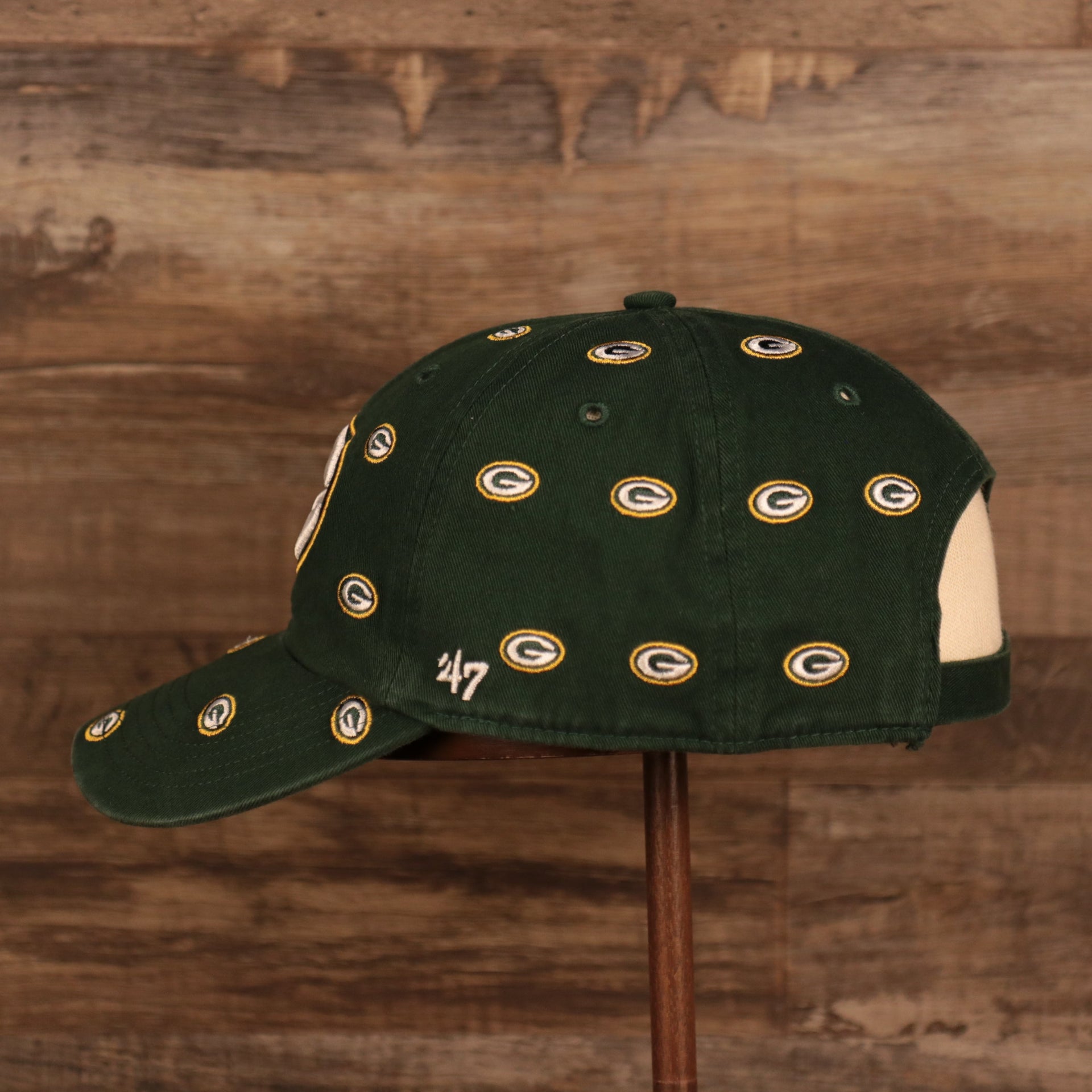 wearers left side of the Green Bay Packers All Over Logo Patch Green Adjustable Dad Hat