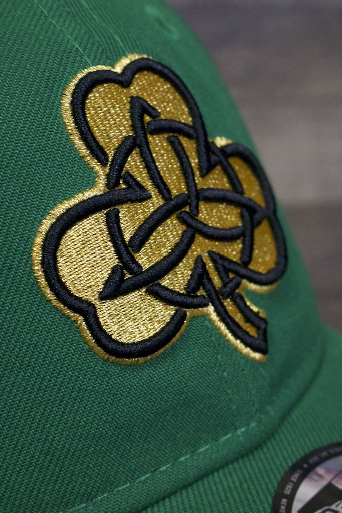 the logo on the Boston Celtics 2019 City Series Dad Hat | Irish Green Adjustable Boston Celtics Baseball Cap with Golden Shamrock is made of gold thread and raised black embroidery on a Celtic design