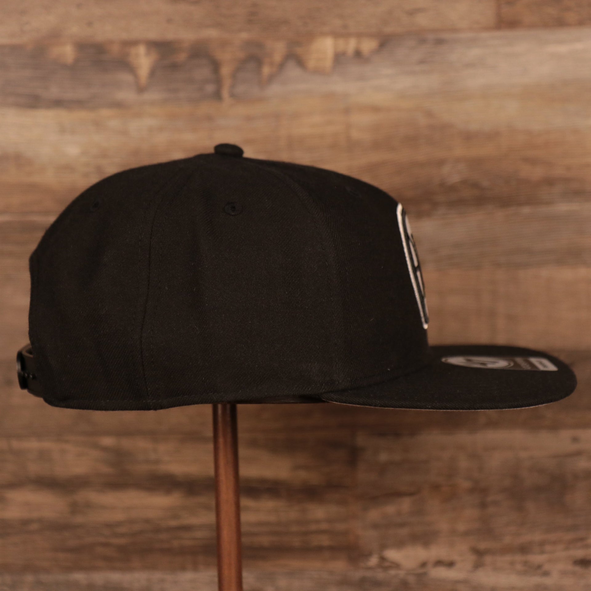 wearers right side of the Los Angeles Clippers Black Adjustable Grey Bottom Snapback Hat