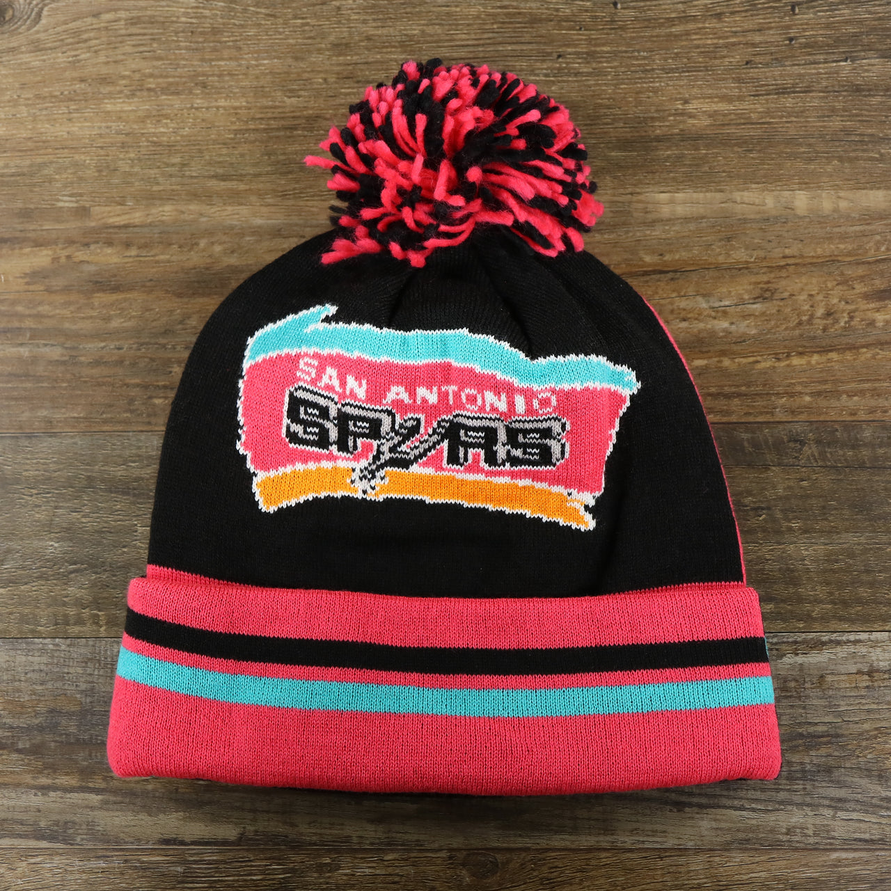 The front of the San Antonio Spurs Retro Logo Two Sided Cuffed Winter Beanie | Pink And Black Winter Beanie