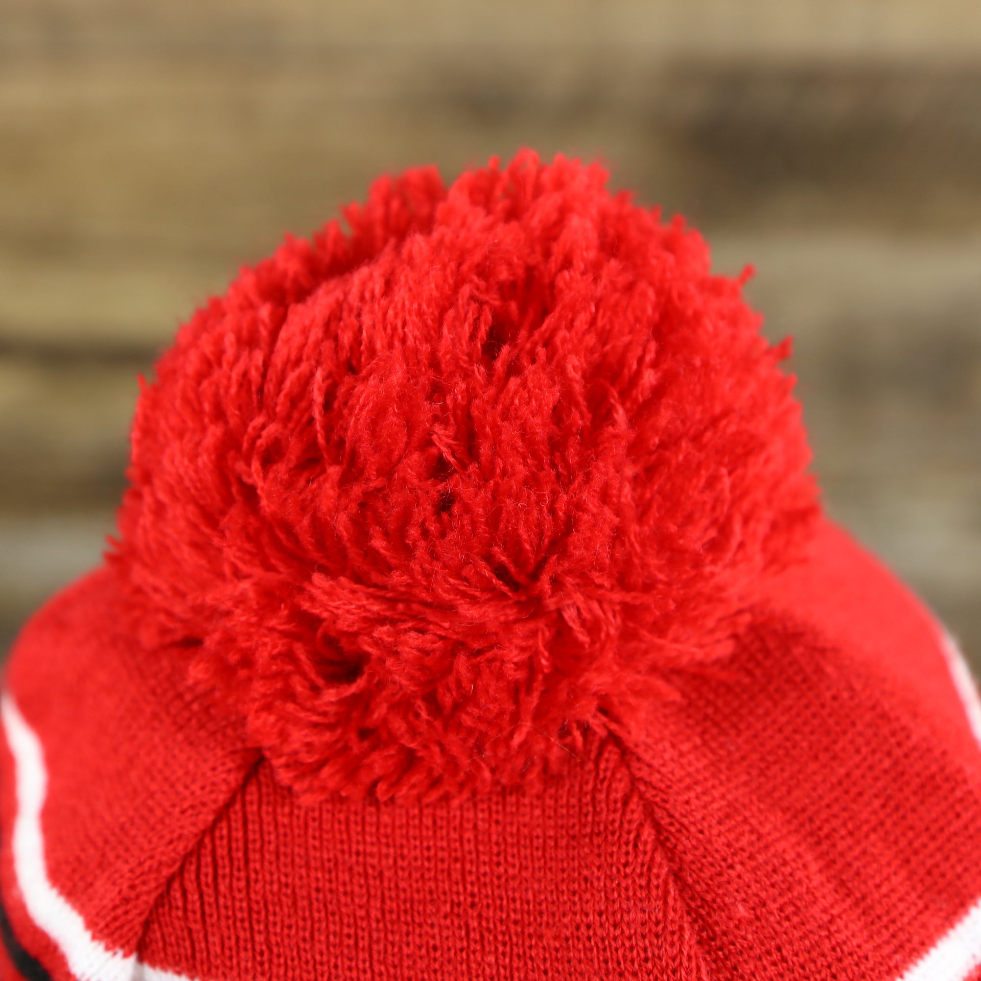 The Pom Pom on the DC Comics Deadpool Mask Logo Deadpool Wordmark Striped Beanie With Red Pom Pom | Red And Black Winter Beanie