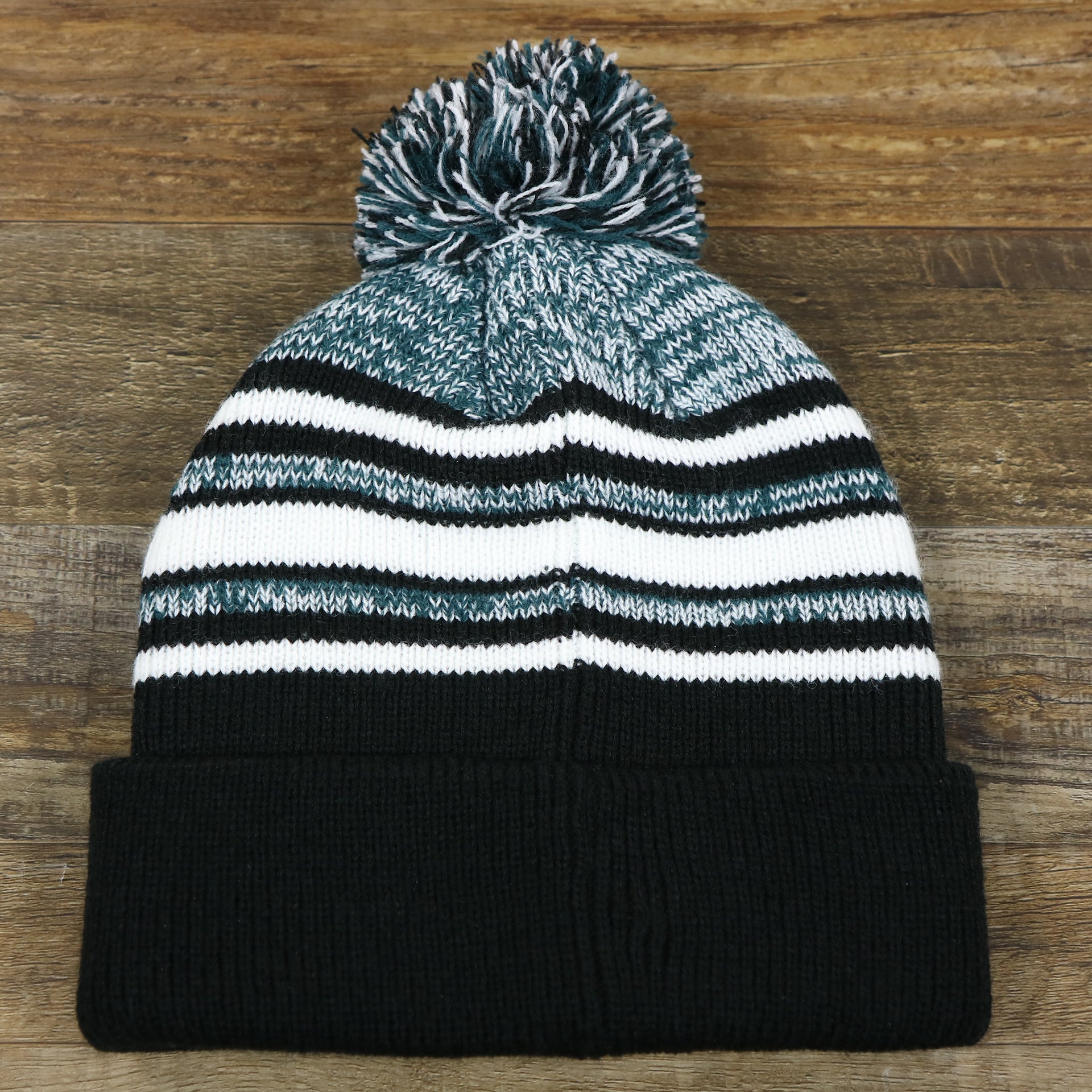 The backside of the Kid’s Philadelphia Eagles Striped Pom Pom Winter Beanie | Black, Midnight Green, And White Beanie