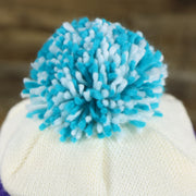 The Pom Pom on the Charlotte Hornets Cursive Wordmark Teal Blue Cuff Pom Pom Winter Beanie | Teal Blue Striped Winter Beanie