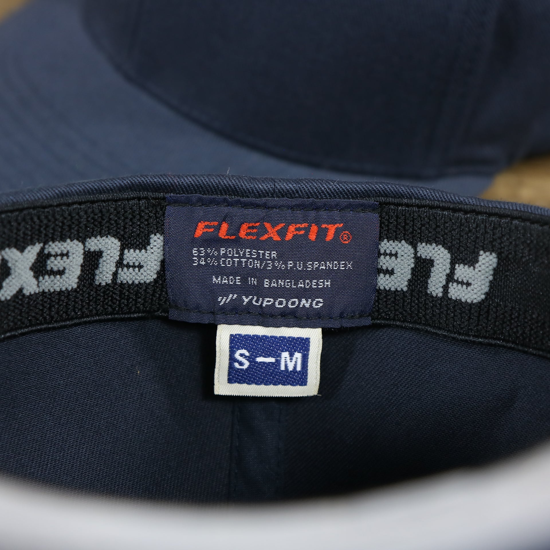 The Flexfit Tag on the Jet Black Bent Brim Silver Bottom Blank FlexFit Cap | Black Flex Cap