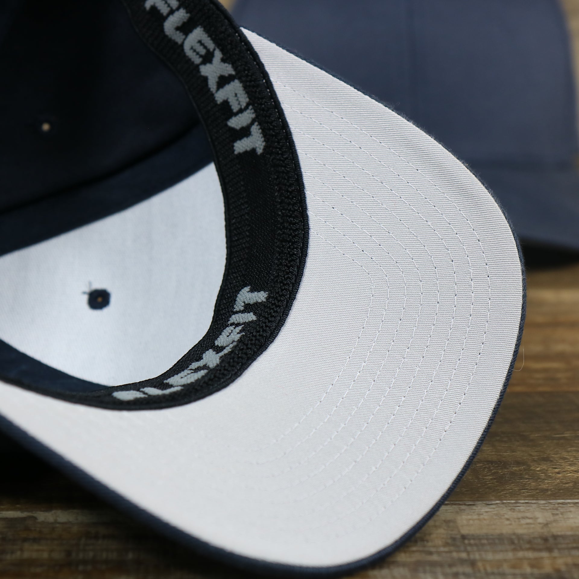 The undervisor on the Jet Black Bent Brim Silver Bottom Blank FlexFit Cap | Black Flex Cap