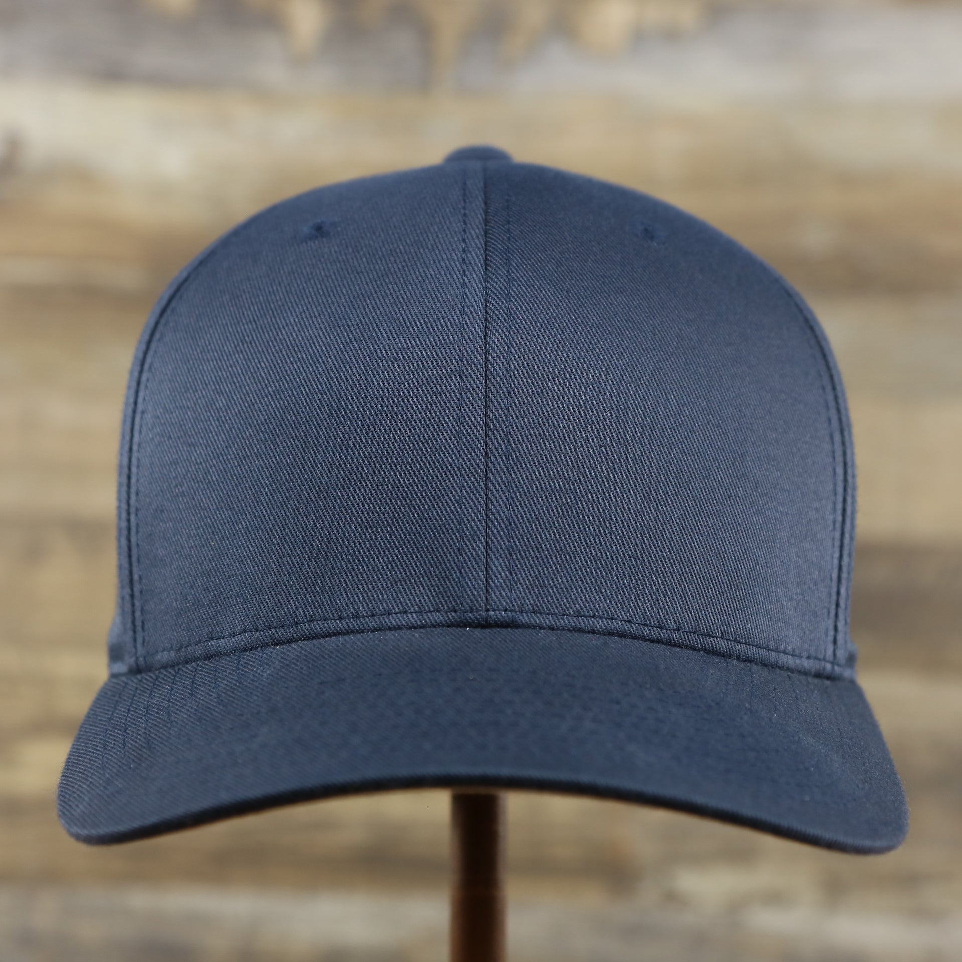 The front of the Jet Black Bent Brim Silver Bottom Blank FlexFit Cap | Black Flex Cap