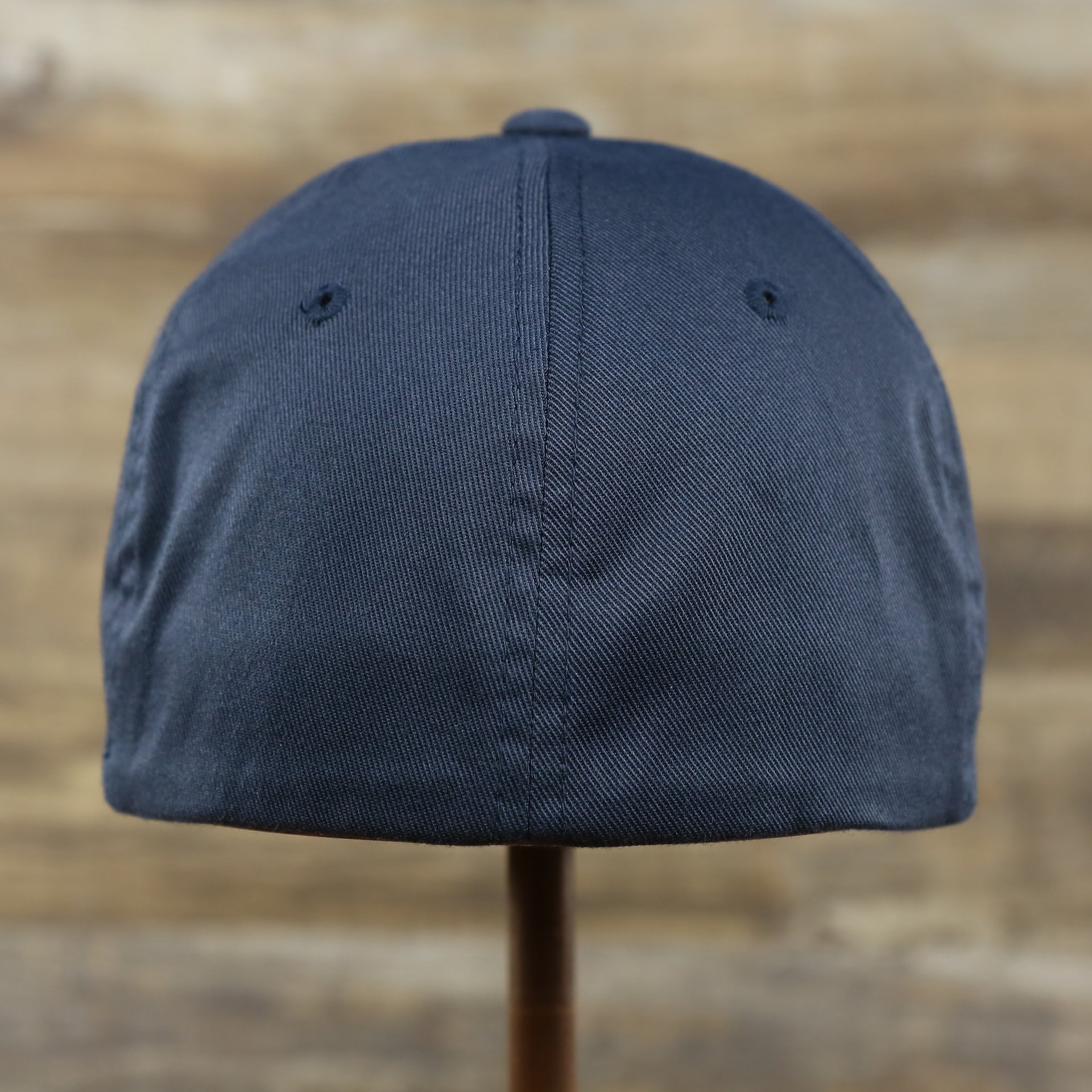 The backside of the Jet Black Bent Brim Silver Bottom Blank FlexFit Cap | Black Flex Cap