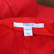 The Port and Company Tag on the Youth Cardinal Red Flat Brim Blank Baseball Hat | Kid’s Red Dad Hat