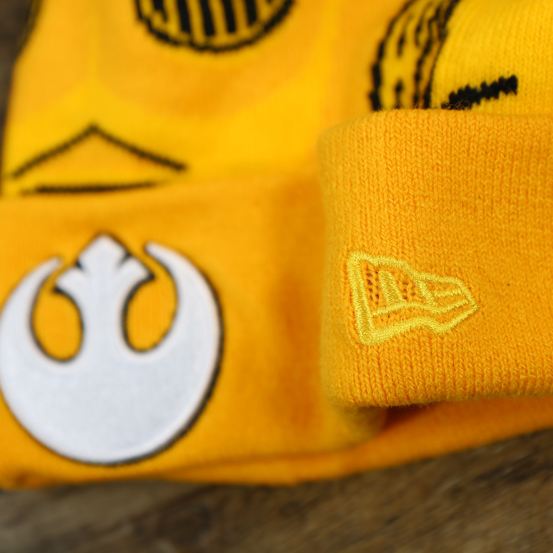 The New Era Logo on the C3PO Rebel Alliance Cuffed Logo Winter Beanie With Pom Pom | Yellow Winter Beanie