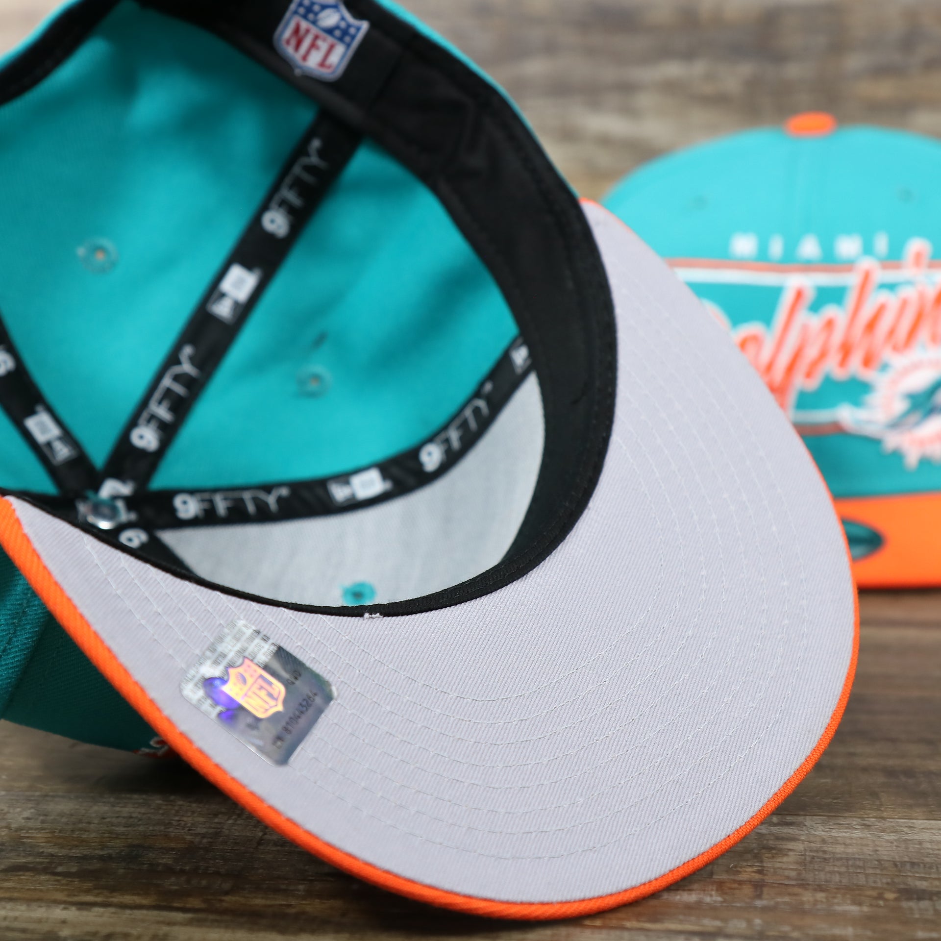 The Gray undervisor on the Miami Dolphins Team Script Gray Bottom 9Fifty Snapback | Aqua and Orange Snap Cap