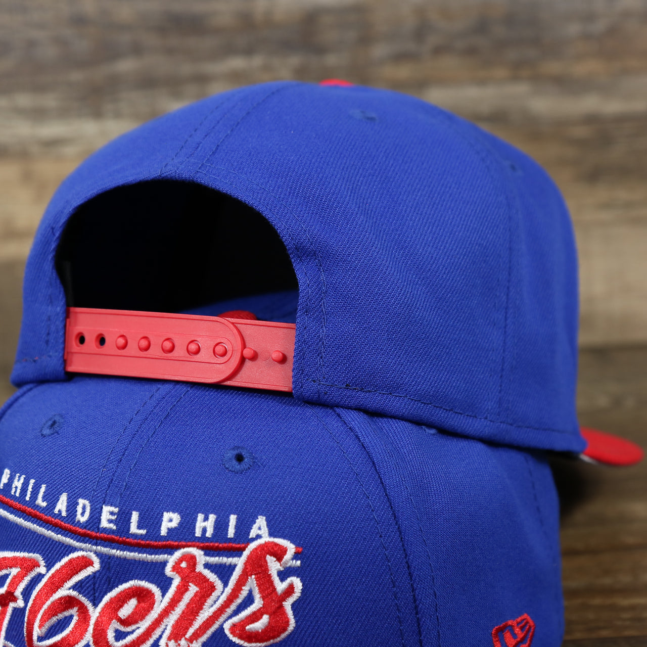 The backside of the Philadelphia 76ers Team Script Gray Bottom 9Fifty Snapback | Royal Blue And Red Snap Cap