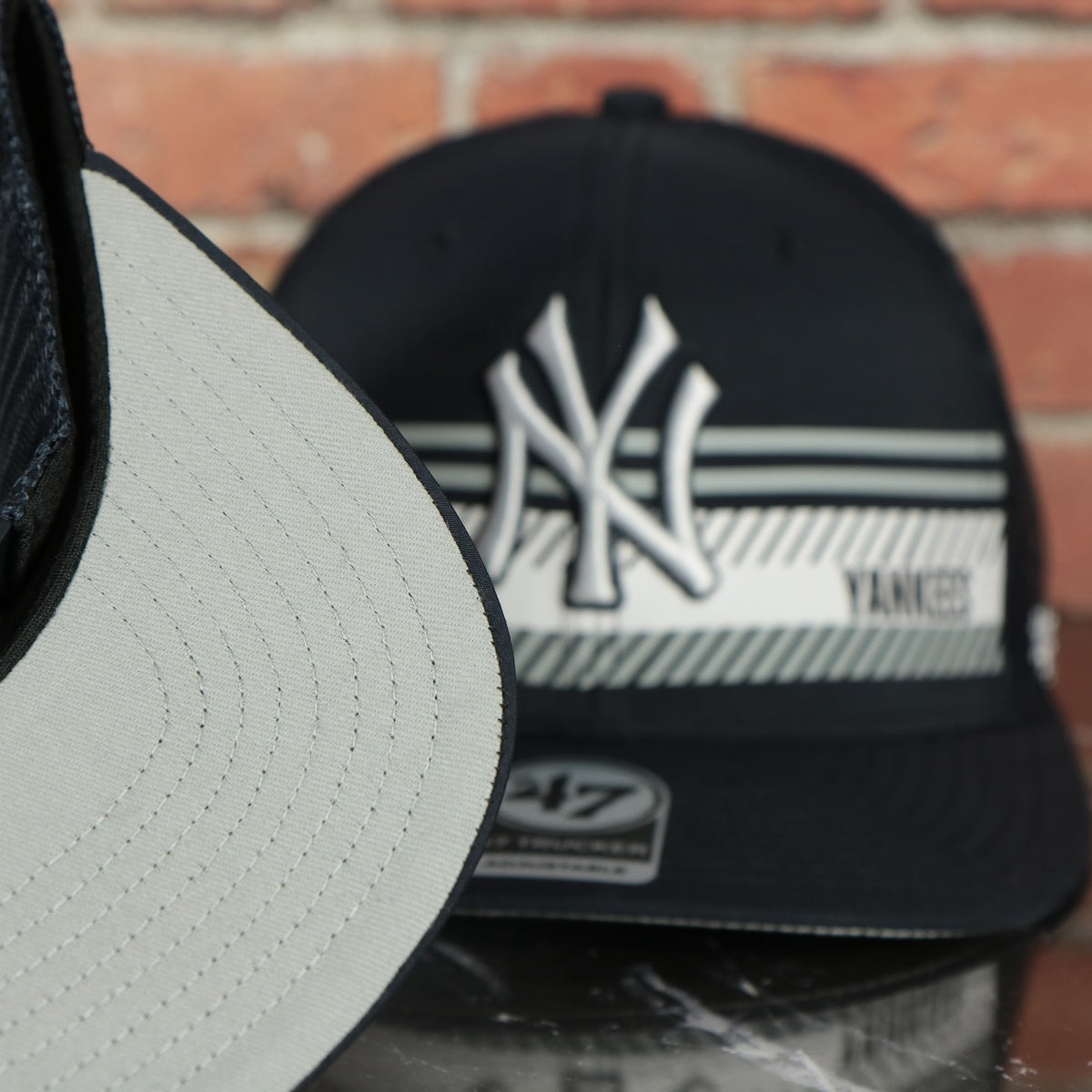 grey under visor on the New York Yankees Mesh Back Printed Graphic Gray Bottom Trucker Hat | Mesh Back Navy Dad Hat