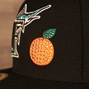 Close up of the iced out orange patch on the Florida Marlins Retro Cooperstown Iced Out Side Patch Orange Florida Gray Bottom 59Fifty Fitted Cap