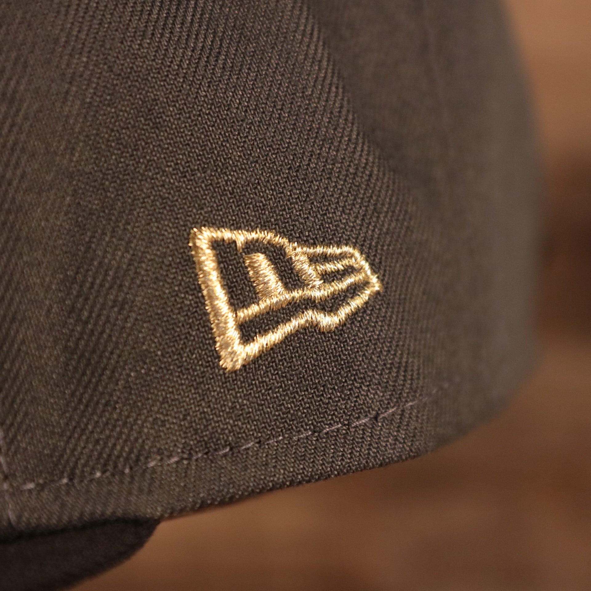 A close up of the New Era flag embroidered in metallic gold on the wearer's left of the Milwaukee Bucks 2021 NBA Champions Trophy Locker Room 9Fifty Snapback Hat